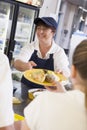 A woman serving lunch to high school students