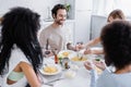 woman serving pasta near cheerful man