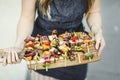 Woman serving vegan barbecue skewers on a wooden board