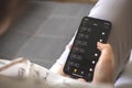 Woman set alarms for wake up on her mobile phone sitting on sofa at home Royalty Free Stock Photo