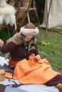 A woman sewing at The Battle of Hastings reenactment in Hastings, UK