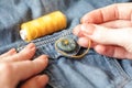 Woman Sewing on button. Thread needle Sewing Button Jeans. Close-up. Authentic Lifestyle Royalty Free Stock Photo