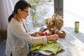 A woman sews homemade dolls