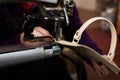 A woman sews a leather strip with a special sewing machine for leather, used in the production of handbags /shoes Royalty Free Stock Photo