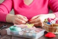 Woman sews red heart shaped toy by needle Royalty Free Stock Photo