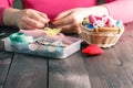 Woman sews red heart shaped toy by needle Royalty Free Stock Photo