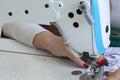 Woman sews on a sewing machine, close up hands.