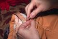 Woman sews torn textile