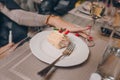 Woman sexy hands of serving strawberry piece of cheesecake with caramel near a glass champagne, jam and Napoleon in a restaurant