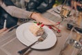 Woman sexy hands of serving strawberry piece of cheesecake with caramel near a glass champagne, jam and Napoleon in a restaurant