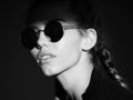 Woman in shadow. Fashion woman with modern sunglasses posing on dark background, accessory. Nice girl, fashion and