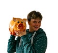 A woman shakes a piggy bank and hears if money is in it.