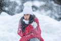 Woman is shaking from cold during windy snowy winter day outdoors despite wearing warm clothes