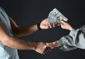 Woman shaking hands with man and offering bribe on background, closeup Royalty Free Stock Photo