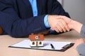 Woman shaking hands with real estate agent at table in office, closeup Royalty Free Stock Photo