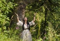 Woman shaman conjures in the forest