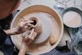 Woman shaping clay vase on a pottery wheel in her private workshop