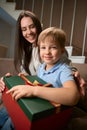 Woman sharing Christmas present with her son while celebrating the winter season Royalty Free Stock Photo