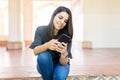 Woman Sharing Information On Message Using Smartphone At Entrance