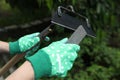 Woman sharpening hoe outdoors, closeup. Gardening tools