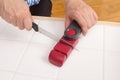 Woman sharpening a knife with sharpener