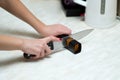 Woman sharpening a knife with a special knife sharpener