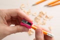 Woman sharpening pencil at light table, closeup