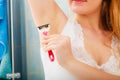 Woman shaving armpit with razor in bathroom Royalty Free Stock Photo