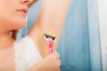 Woman shaving armpit with razor in bathroom Royalty Free Stock Photo