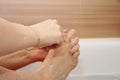 Woman shaving her legs sitting in the bathroom Royalty Free Stock Photo