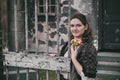 Woman with a shawl at the old wooden lattice gate, portrait of a girl in retro style