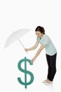 Woman shielding the dollar sign with an umbrella