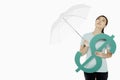 Woman shielding the dollar sign with an umbrella