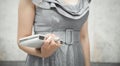 Woman in shining silver dress holding wallet in outdoors