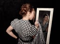 Woman in a shirt looking in the mirror