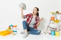 Woman in shock holds bundle of dollars, cash money, sits on floor with instruments for renovation apartment isolated on Royalty Free Stock Photo