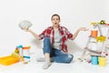 Woman in shock holds bundle of dollars, cash money, sits on floor with instruments for renovation apartment isolated on Royalty Free Stock Photo