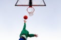 Woman shooting in basketball hoop seen from below Royalty Free Stock Photo