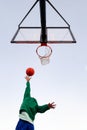 Woman shooting in basketball hoop seen from below Royalty Free Stock Photo