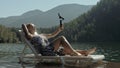 Woman shooting on handheld film gimbal stabilization for smartphone. Girl lie sunbed on pier make selfie. Blogger