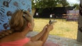 Woman shoots at shooting range with pneumatic gun. Outdoors entertainment for tourists in Thailand.Active leisure on Royalty Free Stock Photo