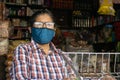 A woman shopkeeper wearing a face mask is waiting for customers in corona pandemic in India.