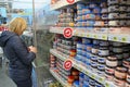 Woman shopper choosing canned fish. Canned seafood on store shelves