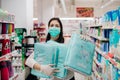 Woman shopper with mask and gloves panic buying and hoarding disposable diapers.Preparing for pathogen virus pandemic quarantine. Royalty Free Stock Photo