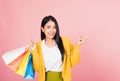 Woman shopper smiling standing holding online shopping bags multicolor in summer pointing finger Royalty Free Stock Photo