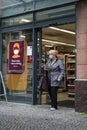 Woman shopper wearing a face mask leaving a food store