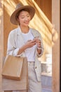 Woman, shopping bag and phone for communication, ecommerce and online chat about sale, discount and savings while Royalty Free Stock Photo