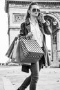 Woman with shopping bags near Arc de Triomphe using cell phone Royalty Free Stock Photo