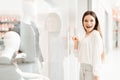 Woman in shopping mall. Girl is standing near store window looking at new dress. Royalty Free Stock Photo