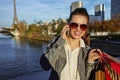 Woman with shopping bags talking on cell phone near Eiffel tower Royalty Free Stock Photo